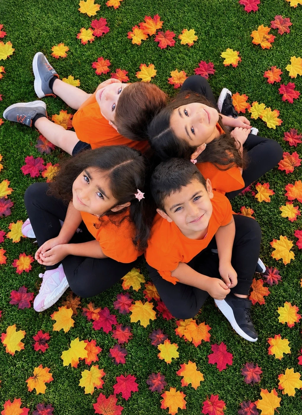 Children together surrounded by colorful autumn leaves