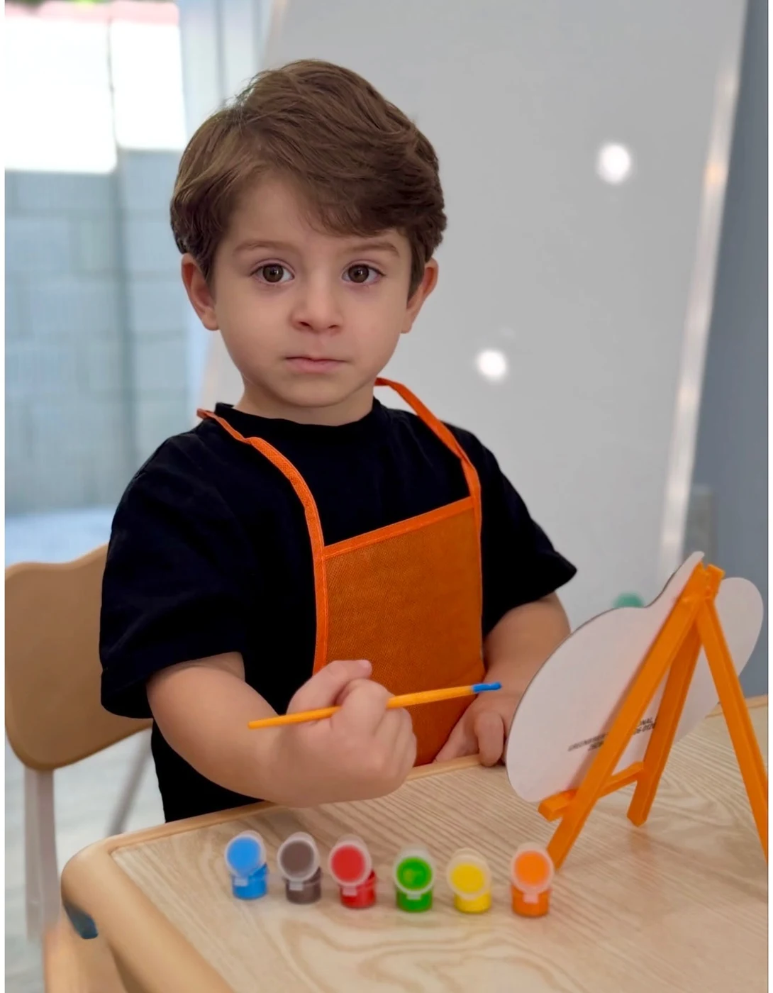 A little artist with paints and an easel