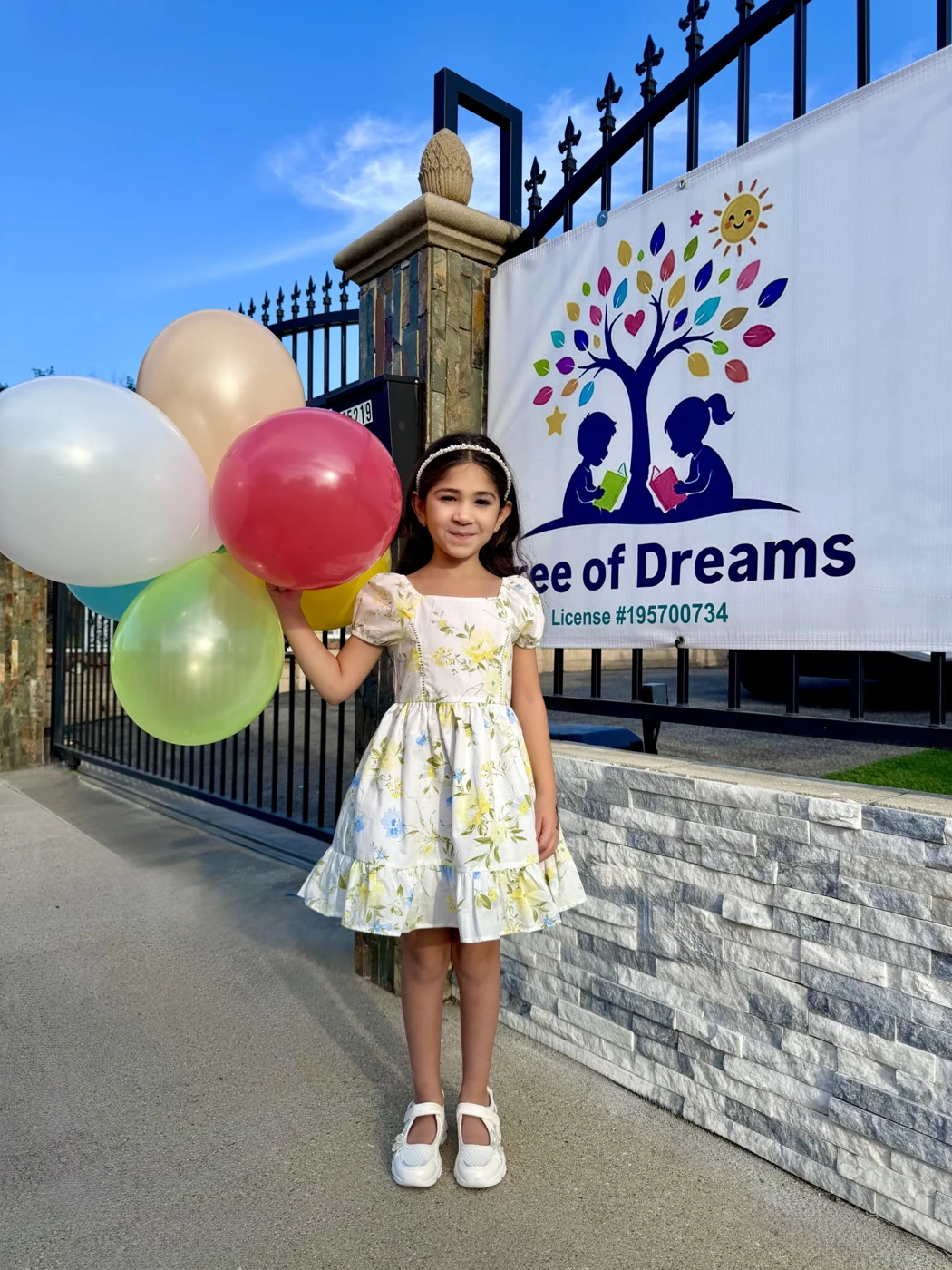 A child beside the Tree of Dreams welcome sign